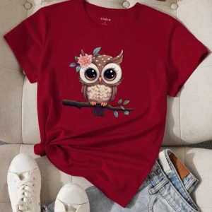 Vinröd t-shirt med uggletryck  - Vinröd t-shirt med ett gulligt uggletryck på bröstet. Ugglan sitter på en gren och har en blomma vid örat. T-shirten har rund hals och korta ärmar, perfekt för en avslappnad stil.