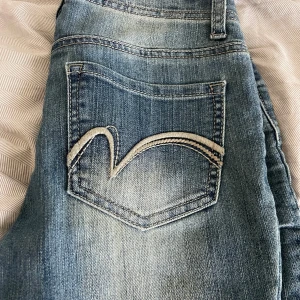 Blå jeans - Snygga blå jeans från Vanilla Star med unik snörning framtill. De har en klassisk femficksdesign och en cool tvättad look. Perfekta för en avslappnad stil.