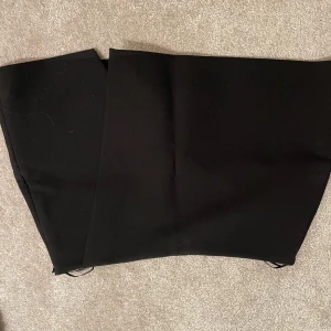 Svarta kostymbyxor - Snygg svart kjol i klassisk stil. Perfekta för en stilren look. Kjolen har en rak passform och är tillverkade i ett elegant material. Finns inbyggda shorts i den! Aldrig använd!