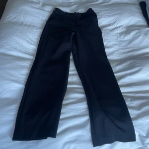 Svarta kostymbyxor - Snygga svarta kostymbyxor vida ben. Perfekta för en stilren look. De har en klassisk design med en elegant passform.