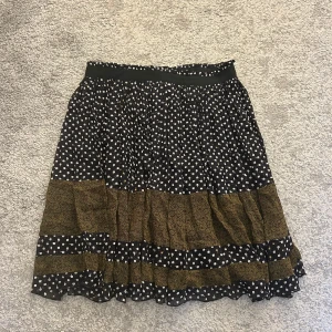 Mönstrad kjol från Scotch & Soda - Snygg kjol från Scotch & Soda med ett mixat mönster av små vita blommor och gröna detaljer. Kjolen har en elastisk midja och är perfekt för en trendig look. Tillverkad i ett lätt och bekvämt material. Hör av er vid funderingar!