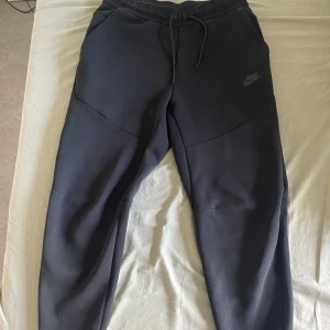 svarta nike tech byxor - svarta nike tech byxor. använt dem 1-2 gånger men de är i bra skick. ursprungspris - 1100kr. säljer byxor eftersom de ej kommer till användning. 