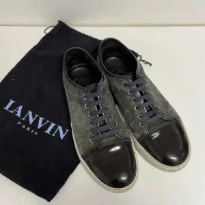 Lanvin sneakers i mocka och lack - Säljer nu mina tvärfeta lanvin skor i storlek UK 8! Skorna är i den sällsynta färgen elephant grey. De är i väldigt bra skick. Hör av er direkt vid fler frågor eller funderingar!