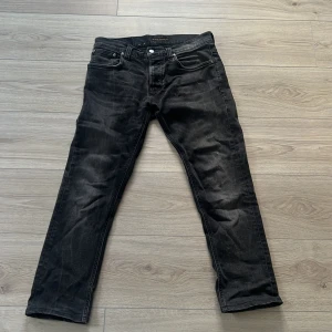 Svarta jeans från Nudie Jeans, 31/34 - Svarta jeans från Nudie Jeans i klassisk grim tim modell. Tillverkade i mjukt denimtyg som sitter skönt hela dagen. Perfekta för dig som gillar en stilren look. W31 L34