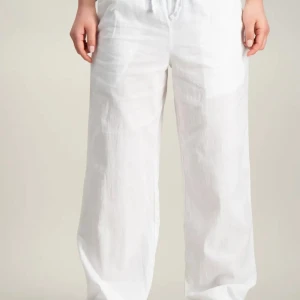 Vita linnebyxor från Gina Tricot - Säljer ett par fräscha vita linnebyxor med avslappnad passform och dragsko i midjan. Byxorna har raka, vida ben och är perfekta för varma dagar. Luftiga och stilrena, passar till allt från sneakers till sandaler. Obs modellen är en tall så passar dig som normalt xxs! Skriv för egna bilder!