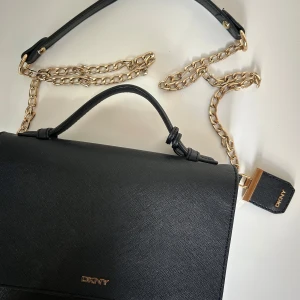 Svart axelväska från DKNY med guldkedja - Snygg väska från DKNY med kedja i guld och handtag
