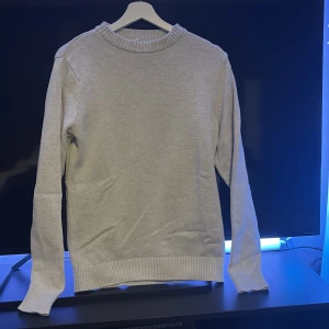 Ljusgrå stickad tröja från dober - Säljer en stilren ljus/vit stickad tröja från dobber . Tröjan har rund halsringning med ribbade muddar vid hals, ärmslut och nederkant. Perfekt för lager-på-lager och enkel att matcha med jeans. Väldigt simpelt men väldigt snyggt och ett måste att ha i sin garderob under höst/vinter. Mycket fint skick, hör av dig!!