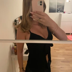 Svart linne från Gina Tricot strl S - Supersnygga svart linne från Gina Tricot med smala axelband och en rosett framtill. Linnet har en figurnära passform och är perfekt för dig som gillar en enkel men chic stil. Materialet känns mjukt och följsamt.