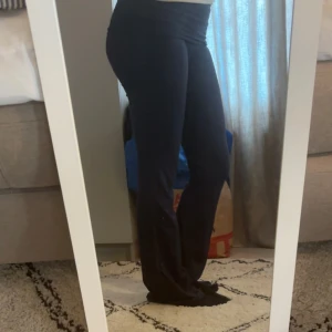 Mörkblå foldover mjukisbyxor från gina - Mörkblå foldover yoga pants med bootcut. Byxorna är i ett mjukt och stretchigt material som sitter skönt och följer kroppen. Perfekta för en chill och avslappnad stil.