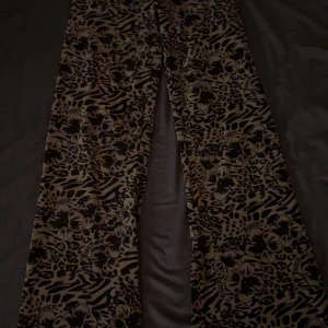 Juicy Couture blommiga leopardbyxor XS - Snygga byxor från Juicy Couture i beige och svart med unik mix av blommigt och leopardmönster. Byxorna har snörning i midjan och är i mjukt material, perfekta för dig som vill sticka ut. Stilen är loose och de har en riktigt trendig vibe. Är även limited edition, nyköpta. Storlek Xs men passar även S. Inget är sönder. Köpta på Raglady.