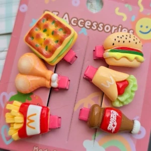 Färgglada hårspännen med matmotiv - Säljer 5 set med roliga hårspännen med matmotiv som hamburgare, pommes, kyckling, fisk, bakelser och läsk. Klämmorna är i plast och har starka färger som röd, gul, orange och beige. Perfekt för dig som vill sticka ut med en lekfull och unik accessoar. Säljs 59kr/set ( 6 st =1 set ) 