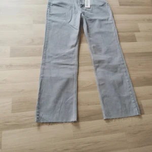 Ljusblå wide jeans från Gina tricot  - Snygga ljusblå jeans från Gina tricot l i modell med raka, vida ben och råa kanter nertill. Klassisk femficksdesign och normalhög midja. Perfekta för en chill och trendig look.