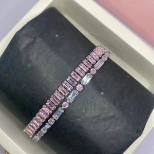 Glittrigt armband med rosa stenar - Snyggt armband med rektangulära och runda stenar i ljusrosa och silverfärg. Stenarna sitter tätt i två rader och ger ett riktigt glittrigt intryck. Ej använd utan kommer från min small business. 