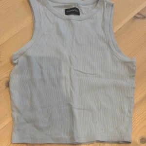 Ljusblå ribbad linnetopp Even&Odd - Snygg ljusblå ribbad linnetopp från Even&Odd. Croppad modell med ärmlös design och rund halsringning. Perfekt till jeans eller kjol för en chill och stilren look.