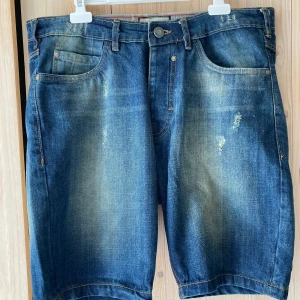 Brave Soul jeansshorts - Riktigt fina, oanvända. Storlek ”Large” har begränsat informationsvärde… Bredden i linningen är 45 cm, vilket innebär att det närmaste måttet i tum är 35. Jag har själv storlek 36 och de passar mig med ganska knapp marginal. Upphämtning i Stockholm fungerar.