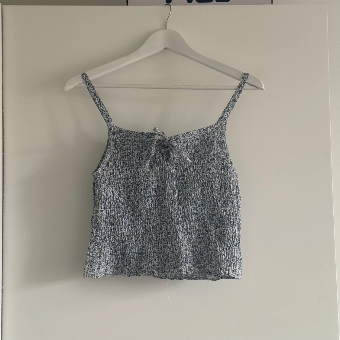 Blåvit smockad linnetopp med knyt