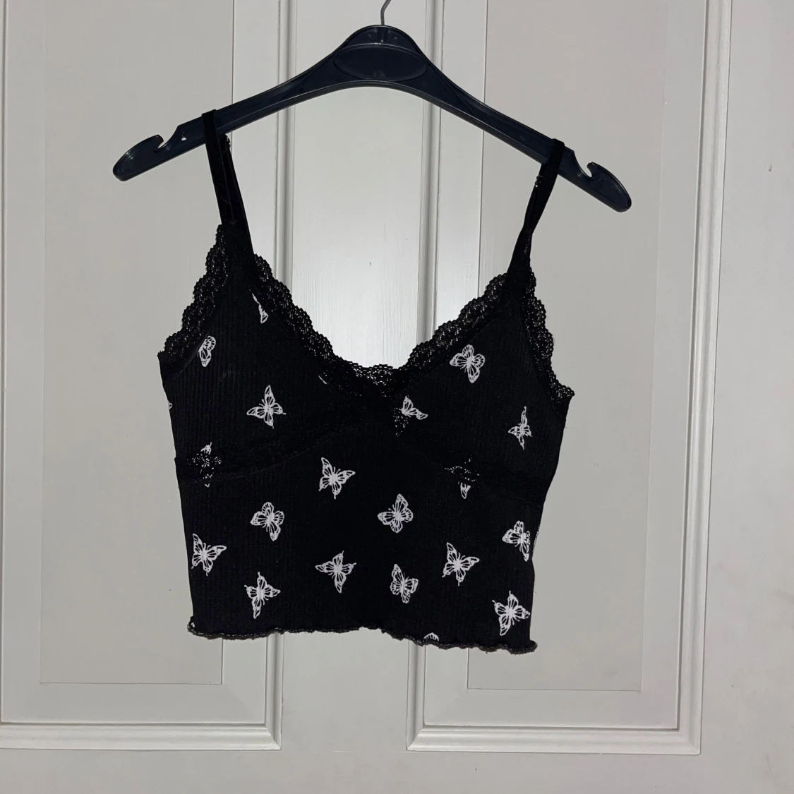 Svart linnetopp med fjärilar och spets