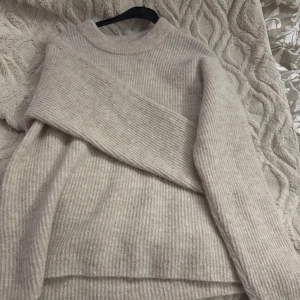 Beige stickad tröja från Lindex - Supermysig beige stickad tröja från Lindex i storlek S. Tröjan har ribbat mönster, rund halsringning och långa ärmar. Perfekt för att styla med jeans och kjolar. Aldrig använd bara på provad! Priset går att diskuteras 