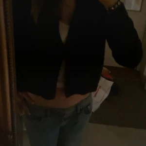 Mörkblå  kofta med knappar - Säljer en mörkblå, kofta med långa ärmar och knappar framtill. Koftan är stickad och har en enkel, stilren look som passar perfekt till jeans eller kjol. Perfekt för dig som gillar en chill och trendig vibe. I strl s