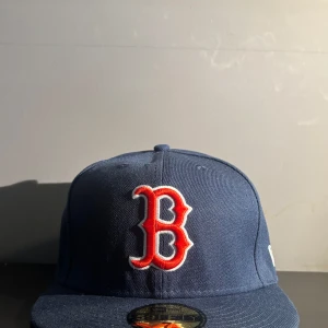 New Era  - Helt ny New Era keps till ett super pris!💸Kepsen har en stilig Boston Red Sox logga. En klassisk marinbåkeps som passar i dom mesta tillfällen. Kepsen är i väldigt fin kvalité och fin inte några anmärkningar på att det inte skulle vara en ny keps. Du får alltså en ny keps till ett kanon pris! Storlek: 7 - ( 55,8 cm) Vill du ha mer information? Eller mer bilder? Skriv direkt!! Jag svarar snabbt😃.  