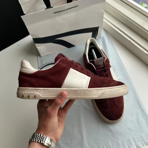 Valentino Flycrew  - Bra skick, endast tre nitar saknas och tyvärr är originala innersulorna sulorna utbytta men annars fint skick på sulorna, mockan och läderdelarna. Skulle säga 7/10 skick. Nypris ca 8000kr. Storlek 43,5 passar 43,5. Mörkröd färg. Passar bra nu till hösten och skolstart! Skriv för mer information🤝