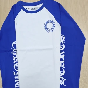 Blåvit långärmad tröja Chrome Hearts - Snygg långärmad tröja från Chrome Hearts i blått och vitt. Tröjan har blå ärmar med tryck längs sidorna och ett stort Chrome Hearts-tryck på ryggen. Materialet är mjuk bomull och passformen är normal. Perfekt för dig som gillar streetwear och tydliga loggor.