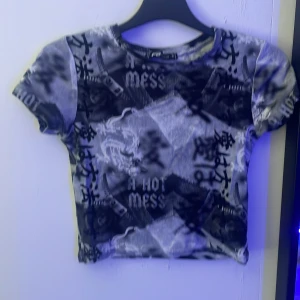 Svart och grå croppad topp med tryck - En magtröja u storlek S den är rätt stretchigt och sitter bra.