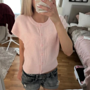 Rosa stickad kortärmad tröja  - Supersöt ljusrosa stickad tröja med kort arm och knappar från Nelly. Helt ny med prislappen kvar. Supermjukt och mysigt material💗skriv vid frågor 
