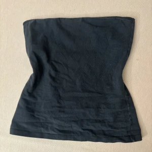 Mörk blå tubtopp från Brandy Melville - Enkel och stilren svart tubtopp från Brandy Melville. Modellen är bandeau och helt ärmlös, perfekt att matcha med jeans eller kjol. Mjuk och stretchig bomull som sitter skönt mot kroppen. Snygg basic för sommaren eller lager på lager.