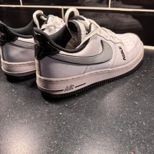 Nike Air Force 1 vita sneakers - 42 -  Nike Air Force 1 sneakers i vitt skinn med grå logga.  Storlek 42