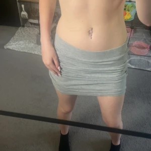 Grå tight kortkjol från 157 - Säljer en enkel och snygg grå kortkjol från märket 157. Kjolen är tight och har en mjuk, stretchig känsla som gör den superbekväm. Perfekt för dig som gillar en clean och stilren look. Passar till allt och är lätt att matcha med olika toppar.