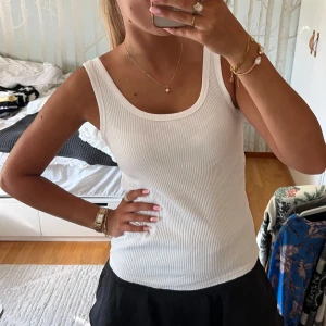 Vit ribbad linnetopp från Lindex - Säljer en klassisk vit ribbad linnetopp från Lindex. Toppen har breda axelband, rundad halsringning och är figurnära i modellen. Perfekt till sommaren och enkel att matcha med allt. Superenkel och stilren basic som alltid funkar. Aldrig använd 