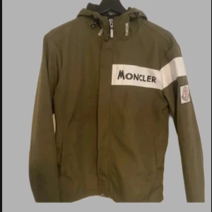 Olivgrön vindjacka från Moncler - Snygg olivgrön vindjacka från Moncler med vit logga på bröstet och ärmen. Skick 9/10