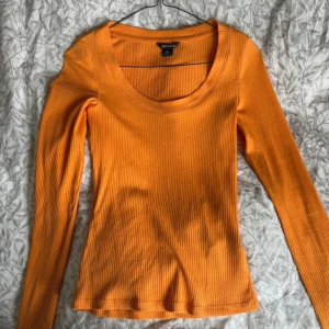 Orange ribbad tröja från Monki - Säljer en snygg orange ribbad tröja från Monki. Tröjan har en rund halsringning och långa ärmar, perfekt för en färgglad look. Passar bra till både jeans och kjol. Hör av dig vid intresse! 🧡använd 1 gång!
