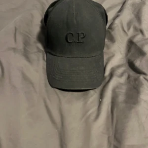 Svart keps med glasögon från C.P. Company - Snygg svart keps från C.P. Company med inbyggda glasögon baktill. 