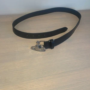 Svart bälte med silverdetaljer - Snyggt svart bälte från Vivienne Westwood, Fint skick. Obs R€p. Kontakta gärna vid frågor! 