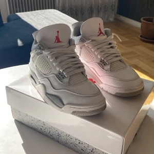 Nike Air Jordan 4 Retro - Säljer ett par stilrena Nike Air Jordan 4 Retro i vit färg med röda detaljer. Skorna har en klassisk design med snörning och rund tå. Perfekta för sneaker-entusiaster som vill ha en ikonisk look. Ni får även med creas skydd✨