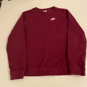 Vinröd Nike tröja - Säljer en vinröd tröja från Nike med rund hals och långa ärmar. Perfekt för en avslappnad stil. Nike-loggan är tryckt i vitt, litet på bröstet. Passar bra till både jeans och träningsbyxor. Riktigt fräsch tröja som passar till allt, riktigt fet vinröd färg, till dig som vill få in lite mer färg i dina outifts. Skick: 9/10, Färg: 10/10, Pris: 99kr. Ifall du har några funderingar kring tröjan, eller priset så är de bara att höra av dig i pm!