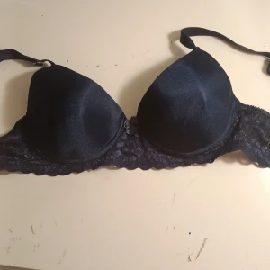 Mörkblå bh med spetsdetaljer🍬 - Snygg mörkblå bh med släta kupor och spetsdetaljer längs kanterna. Den har en liten rosett mellan kuporna för en extra touch. Justerbara axelband för perfekt passform.
