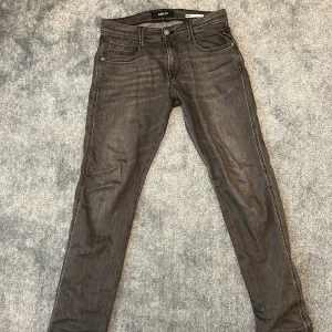 Grå Replay Anbass jeans - Snygga grå jeans från Replay, modell Anbass. De har en slim fit passform och klassisk femficksdesign. Perfekta för en stilren look med en modern touch.