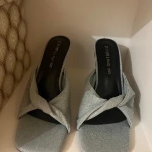 Grå klackskor från Zenwint - Snygga grå klackskor från Zenwint med en elegant twistad detalj över foten. Skorna har en öppen tå och en stilren design som passar perfekt för festliga tillfällen.