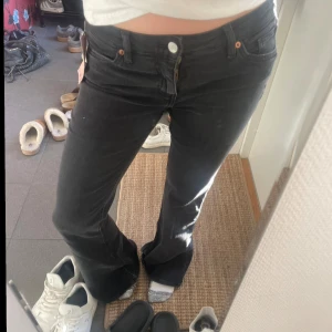 Svarta utsvängda jeans från Monki - Säljer ett par svarta utsvängda jeans från Monki, modell Katsumi. De är lågmidjade och tillverkade i ekologisk och återvunnen bomull med stretch. Perfekta för en trendig look! De är helt nya och aldrig använda. 💕