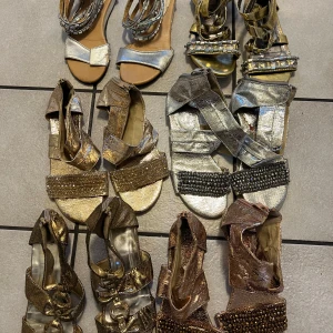 Glittriga sandaler i olika färger storlek 36/37 - Säljer ett set av glittriga sandaler i olika färger. De finns i guld, silver och brons med dekorativa pärlor och paljetter. Perfekta för att lysa upp vilken outfit som helst. Säljes som paket.
