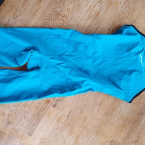 Blå tävlings baddräkt från Finis - Säljer en blå baddräkt från Finis. Den är tillverkad i ett syntetmaterial med svart insida och har en smidig passform för optimal rörelsefrihet i vattnet. Jag var ungefär strl 36 när jag hade den. Fint, begagnat skick!