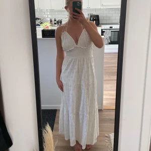 Vit långklänning med broderad spets - Jättefin vit långklänning från Asos med öppen rygg. Använd endast en gång på midsommar. Fint skick! Strl 36/38                                        Slutsåld