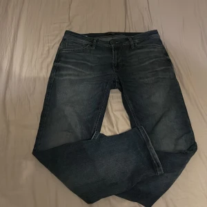 Blå jeans från Jack & Jones - Säljer ett par klassiska blå jeans från Jack & Jones. De har en normal passform och är tillverkade i denim. Perfekta för en avslappnad stil och i en skit snygg färg