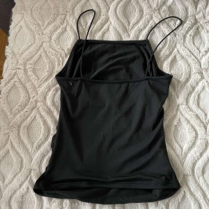 Svart ärmlös linnetopp - Snygg svart enkelt linne från SHEIN. Väldigt skönt material mot huden. Passar perfekt till en kjol på en varm sommarkväll. Tyvärr fått ett litet hål på sidan av linnet.