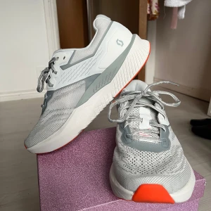 Gråa löparskor från Scott - Snygga och funktionella gråa löparskor från Scott med orange detaljer. Skorna har snörning och en bekväm passform, perfekt för löpning och träning. De har en modern design med en robust sula för extra grepp. PRIS KAN DISKUTERAS!😁Nypris 700