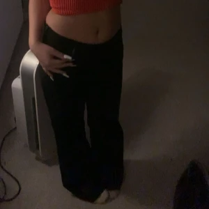 Svarta Low waist kostymbyxor  - Snygga svarta byxor från Message med en klassisk design. Byxorna har en rak passform och är perfekta för en stilren look. De är tillverkade i ett bekvämt material som passar för olika tillfällen, säljer denna för den passar inte mig längre, de finns en dragkedja på sidan av byxorna.