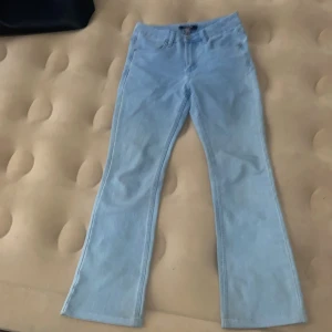 Ljusblå bootcut jeans från Ellos - Snygga ljusblå jeans från Ellos, modell Fresh Spirit. Byxorna har klassisk femficksdesign och bootcut-ben som ger en retrovibe. Tillverkade i mjukt denimtyg, perfekta för dig som gillar en avslappnad men trendig look. Dom är i väldigt bra condition och har knappt haft på dom eftersom jag har så många jeans 